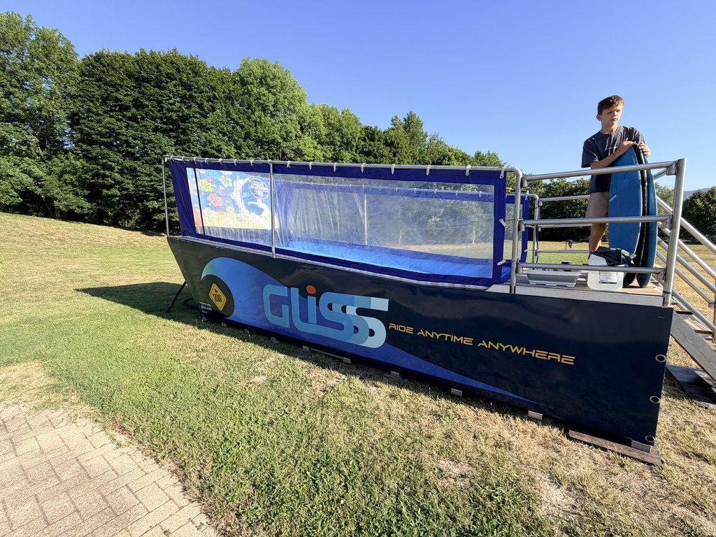 Enfant sur la plateforme du PocketSurf avec sa planche, La Vallée Bleue, été 2026